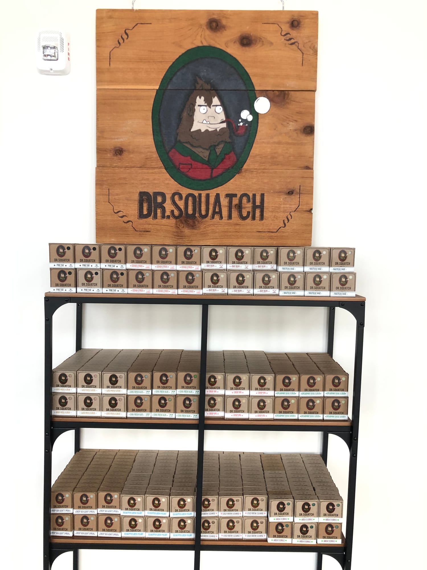 Wooden Dr. Squatch sign above shelves of bar soap